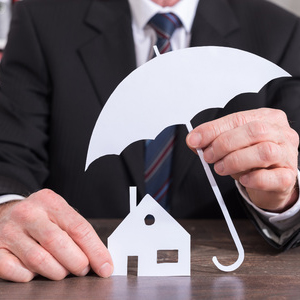 61684177 - house protected with an umbrella by an insurer - insurance concept